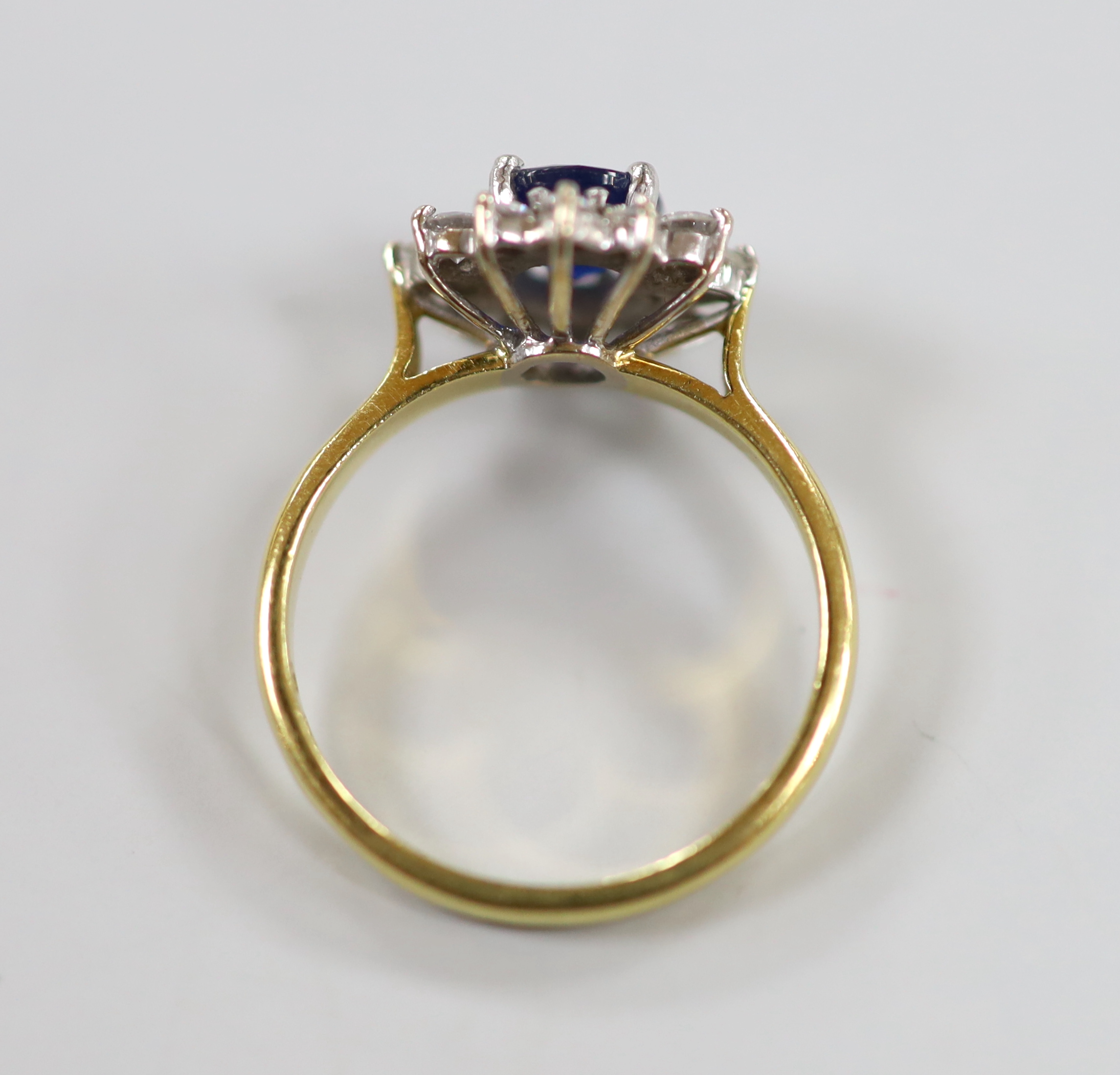 A modern 18ct gold sapphire and diamond set oval cluster ring, size J, gross weight 3.2 grams.